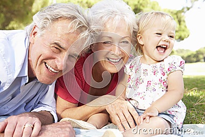 Grandparents And Granddaughter In Park Together Stock Photo