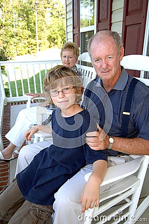 Grandparents with grandson on porch Stock Photo