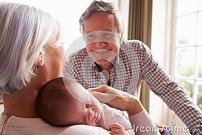 Grandparents Holding Sleeping Newborn Baby Granddaughter Stock Photo