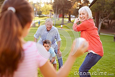 Grandparents Playing Baseball With Grandchildren In Park Stock Photo