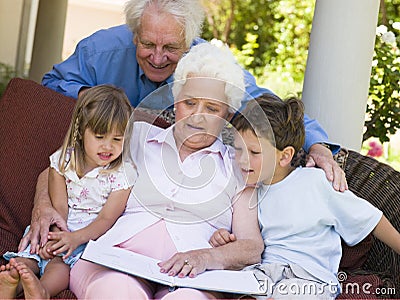 Grandparents reading to grandchildren Stock Photo