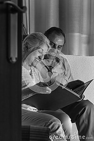 Grandparents reviewing their album of family photographs Stock Photo