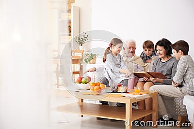 Grandparents showing photo album to their grandchildren Stock Photo