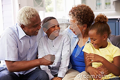 Grandparents and their young grandchildren relaxing at home Stock Photo