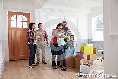 Grandparents Visiting Hispanic Family In New Home Stock Photo