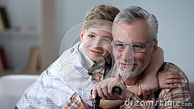 Grandson cuddling grandfather with love, precious family minutes, elderly care Stock Photo