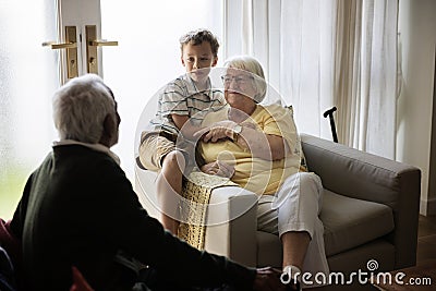 Grandson is in a living room with grandparents Stock Photo