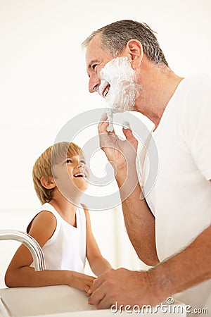 Grandson Watching Grandfather Shaving In Bathroom Stock Photo