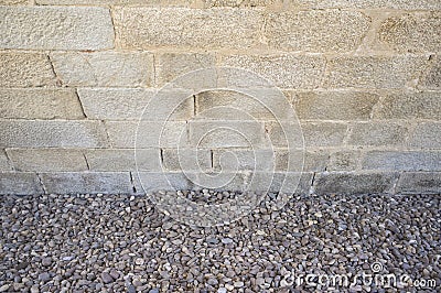 Granite ashlars wall with river pebble stones as ground Stock Photo