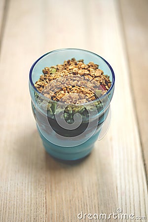 Granola Parfait in Blue Tumbler on Wooden Surface Stock Photo