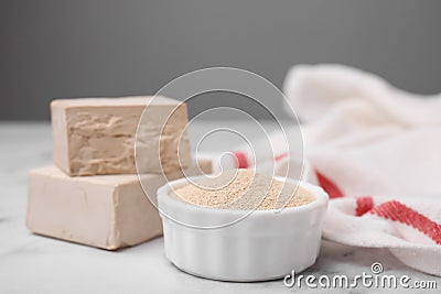 Granulated and compressed yeast on white marble table, closeup Stock Photo
