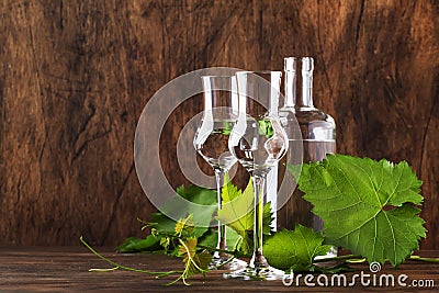 Grape vodka, pisco - traditional Peruvian strong alcoholic drink in elegant glasses on vintage wooden table, copy space Stock Photo