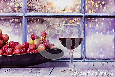 Grapes, glass of red wine on a table against window. Still Life fruit Alcoholic. Stock Photo