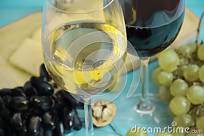 Grapes, a glass of wine nut autumn rustic beverage cheese on a blue wooden backgrounnut Stock Photo