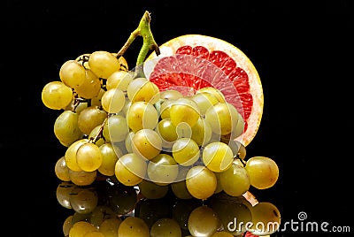 Grapes and grapefruit black background Stock Photo