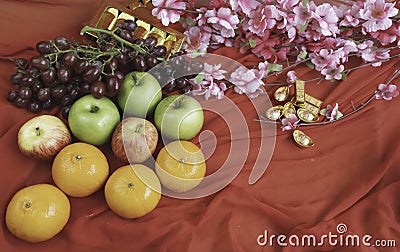 Grapes,Oranges and Apples put beside Gold miniature with Chinese auspicious words Stock Photo