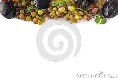 Grapes on white background. Ripe grape, plums and mint leaves at border of image with copy space for text. Top view. Various fresh Stock Photo