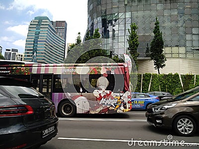 Graphic art on public bus in traffic in Singapore Editorial Stock Photo