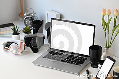 Graphic designer or photographer workspace with empty screen laptop and camera accessory. Stock Photo