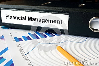 Graphs and file folder with label Financial Management. Stock Photo