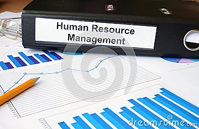 Graphs and file folder with label Human Resource Management. Stock Photo