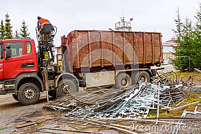 A grapple truck loads scrap industrial metal for recycling. Editorial Stock Photo