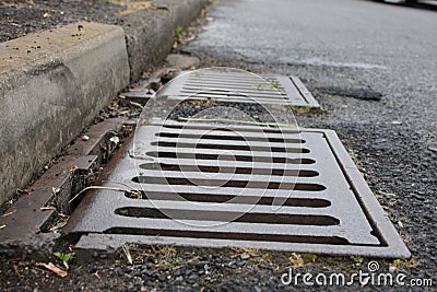 Grate of a storm sewer drain up close perspective Stock Photo