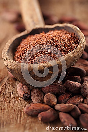 Grated dark 100% chocolate in spoon on roasted cocoa chocolate Stock Photo
