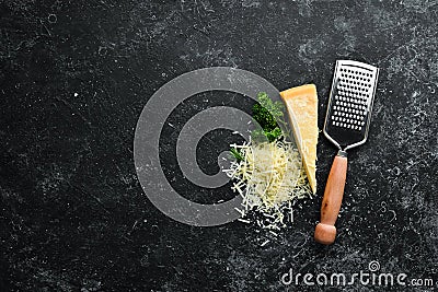 Grated hard cheese on a black stone background. Parmesan. Top view. Stock Photo