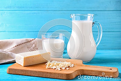 Grated hard cheese with milk on wooden board Stock Photo