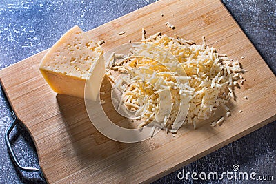 Grated piece of milk yellow cheese. Stock Photo