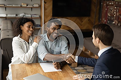 Grateful black family couple handshake with insurer before signing contract Stock Photo