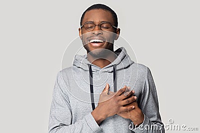 Grateful black male believer touch heart feel thankful Stock Photo