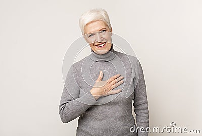 Grateful senior woman keeping hand on her chest Stock Photo