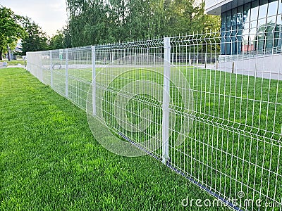 Grating wire industrial fence panels, pvc metal fence panel and neatly trimmed lawn Stock Photo