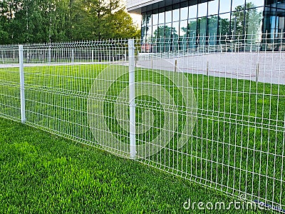 Grating wire industrial fence panels, pvc metal fence panel and neatly trimmed lawn Stock Photo