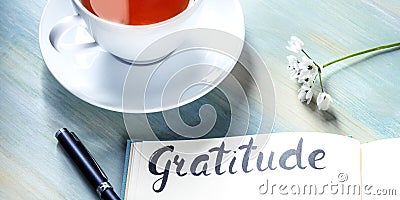 Gratitude journal panorama with a cup of tea and a flower Stock Photo