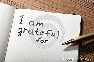 Gratitude Word With Pen On Notebook Stock Photo