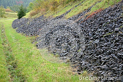 Gravel gray basalt, coarse is used as drainage strips above the road in the notch of the highway. The stones can serve as a shelte Stock Photo