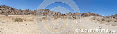 gravel road and Dolerite boulder buttes in desert, near Hobas, Namibia Stock Photo