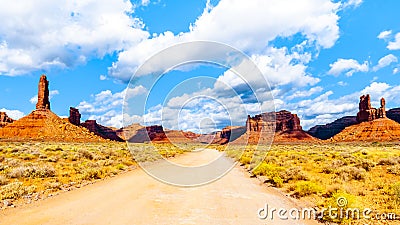 Gravel Road winding through the landscape of Red Sandstone Buttes and Pinnacles in the desert landscape in the Valley of the Gods Stock Photo