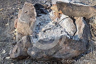 Gray and brown big stones and white ash in a fireplace in the forest Stock Photo