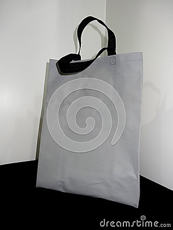 Gray color bag and black handle, Non woven Bag, Polypropylene Non Woven Bag on table Stock Photo