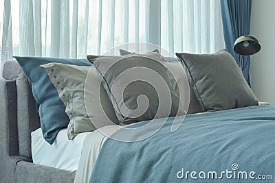 Gray and deep blue pillows setting on bed in deep blue color scheme Stock Photo