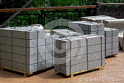 Gray granite border piled in a pile on a pallet for transportation. Stock Photo