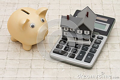 A gray house, piggy bank and calculator on stone background Stock Photo