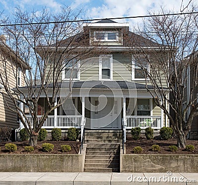 Gray House in Urban Setting with Bare Winter Trees Stock Photo