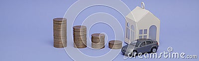 Gray machine model and home with coins in the form of a histogram on a purple background. Concept of lending, savings, sale, lease Stock Photo