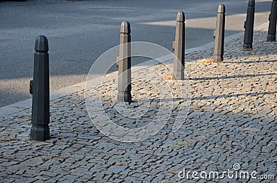 Gray metal bollards are used to protect pedestrians in the pedestrian zone or in the park on the promenade. gray pillars prevent p Stock Photo