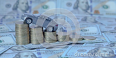 A gray model of a car with coins in the form of a histogram on a dollars background. Concept of lending, savings, insurance Stock Photo